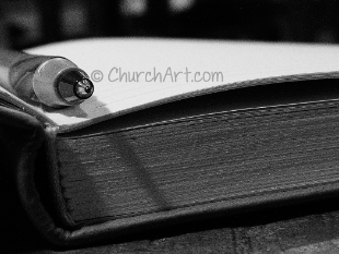 Bible Study Clip-Art photo of edge of open Bible with a pen
