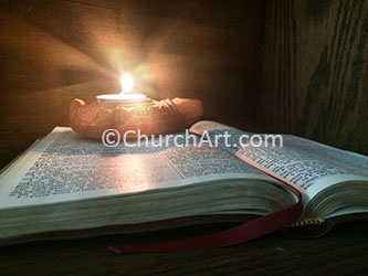 Burning oil lamp sitting on open Bible as background photo
