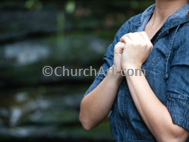 Woman with hands clasped over her heart and praying as background photo